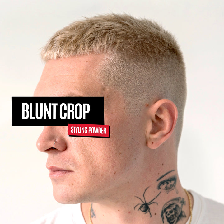 Side profile of a man with a short blonde 'blunt crop' haircut, wearing a white t-shirt and displaying tattoos on his neck. A black label overlay reads 'BLUNT CROP' and a red label overlay reads 'STYLING POWDER'.